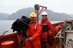 Two journalist equiped with microphone and camera onboard the icebreaker CCGS Amundsen